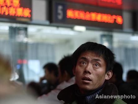 A man looks at an electronic schedule board at Beijing West Railway Station, January 1, 2009. [Asianewsphoto]