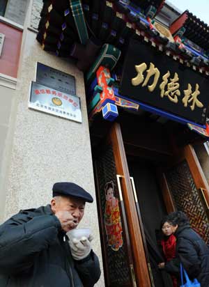 An elder enjoys a bowl of hot porridge provided by Gongdelin Vegetarian Restaurant in Beijing, capital of China, on Jan. 3, 3008. 