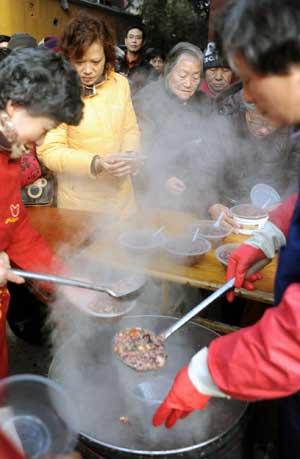  Local residents queue for Laba porridge at Pilu Temple in Nanjing, capital of east China's Jiangsu Province, on Jan. 3, 2009. 