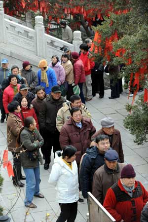 Local residents queue for Laba porridge at Pilu Temple in Nanjing, capital of east China's Jiangsu Province, on Jan. 3, 2009. 