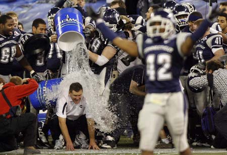 Connecticut Huskies head coach Randy Edsall kneels as water is poured on him in celebration before his team defeated the Buffalo Bulls to win their NCAA International Bowl football game in Toronto January 3, 2009.