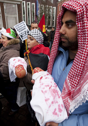 A man and woman hold blood-smeared dolls during an anti-Israel demonstration in Amsterdam January 3, 2009. 
