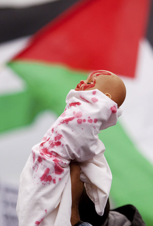 A man holds up a blood smeared doll during an anti Israel demonstration in Amsterdam January 3, 2009. 