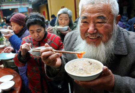 Residents eat free Laba porridge provided by a temple in Nanjing, capital of east China's Jiangsu province, January 3, 2009. Laba, often regarded as the start of celebrations for the Chinese lunar New Year, falls on the eighth day of the 12th lunar month. Eating porridge on Laba is believed to bring good fortune in the New Year. [Xinhua]