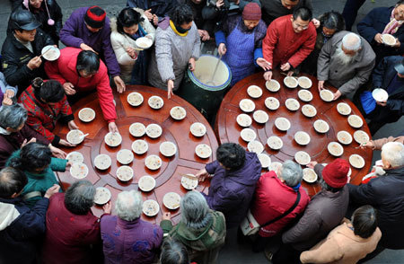 Residents queue up to get free Laba porridge provided by a temple in Nanjing, capital of east China's Jiangsu Province, January 3, 2009. Laba, often regarded as the start of celebrations for the Chinese lunar New Year, falls on the eighth day of the 12th lunar month. Eating porridge on Laba is believed to bring good fortune in the New Year. [Xinhua]