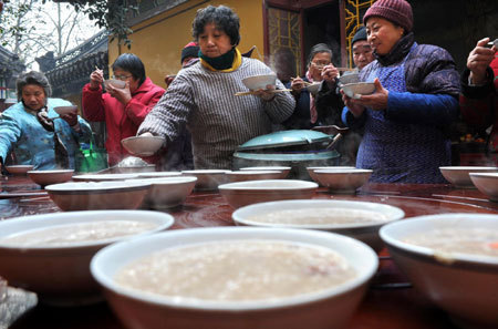 Residents eat free Laba porridge provided by a temple in Nanjing, east China's Jiangsu Province, January 3, 2009. Laba, often regarded as the start of celebrations for the Chinese lunar New Year, falls on the eighth day of the 12th lunar month. Eating porridge on Laba is believed to bring good fortune in the New Year. [Xinhua]