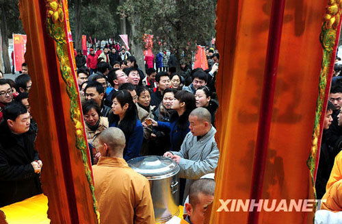 People eat free Laba porridge provided by a Shaolin Temple in Jiangsu Province, January 3, 2009. Laba, often regarded as the start of celebrations for the Chinese lunar New Year, falls on the eighth day of the 12th lunar month. Eating porridge on Laba is believed to bring good fortune in the New Year. [Xinhua]