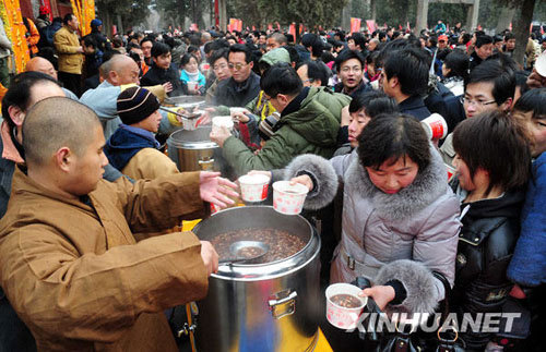 People eat free Laba porridge provided by a Shaolin Temple in Jiangsu Province, January 3, 2009. Laba, often regarded as the start of celebrations for the Chinese lunar New Year, falls on the eighth day of the 12th lunar month. Eating porridge on Laba is believed to bring good fortune in the New Year. [Xinhua]