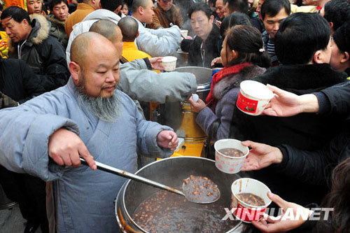 People eat free Laba porridge provided by a Shaolin Temple in Jiangsu Province, January 3, 2009. Laba, often regarded as the start of celebrations for the Chinese lunar New Year, falls on the eighth day of the 12th lunar month. Eating porridge on Laba is believed to bring good fortune in the New Year. [Xinhua]