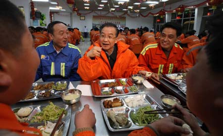 Chinese Premier Wen Jiabao (C) talks with workers as they have supper together at a dining hall of the Qingdao port in Qingdao, east China's Shandong Province, Jan. 1, 2009. Wen visited companies, markets, communities and rural areas in Qingdao on Jan. 1-2. 
