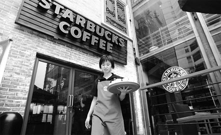 A Starbucks employee serves at a shop in Chongqing, southwestern China. [China Daily]