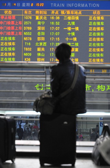 A man looks up at a train information board at Guangzhou Railway Station in Guangzhou, south China's Guangdong province January 4, 2009. Guangzhou Railway Station has seen a sharp rise in the number of travellers since the New Year holiday started on January 1. [Xinhua]
