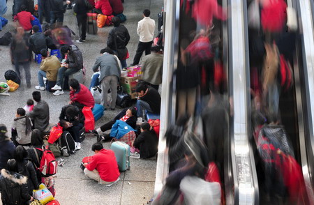 Travellers wait inside Guangzhou Railway Station to board trains back home in Guangzhou, south China's Guangdong province January 4, 2008. [Xinhua]