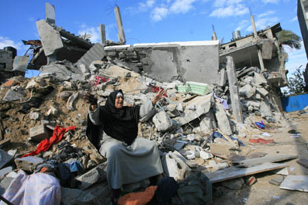 A Palestinian woman reacts on the rubble of her destroyed house after it was hit in an Israeli airstrike in the Rafah refugee camp, southern Gaza Strip, Jan. 3, 2009. The 