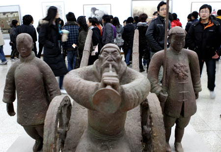 The visitors view a sculpture presented on the Fine Arts Exhibition of the Yangtze River Delta Region memorizing the 30th Anniversary of China's reforms and opening up campaign, in Hangzhou, capital of east China's Zhejiang Province, Jan. 3, 2009. 