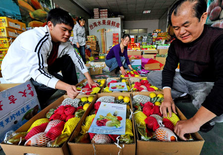 Vendors from Tainan County of southeast China's Taiwan arrange fruits transported from Taiwan at a wholesale center in Xiamen, southeast China's Fujian Province, Jan. 4, 2009. [Zhang Guojun/Xinhua]