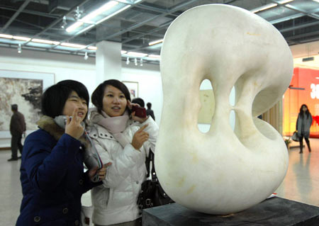 The visitors view a sculpture presented on the Fine Arts Exhibition of the Yangtze River Delta Region memorizing the 30th Anniversary of China's reforms and opening up campaign, in Hangzhou, capital of east China's Zhejiang Province, Jan. 3, 2009. [Cheng Ruixin/Xinhua]