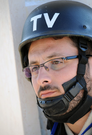 A journalist with helmet and bullet-proof vest looks into north Gaza Strip at the top of a hill near Gaza border, south Israel, Jan. 4, 2009. Hundreds of journalist and reporters from all over the world swarm into Israel and the west bank since Israel began the air strike to Gaza Strip on Dec. 27, 2008.[Yin Bogu/Xinhua]