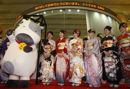  Women dressed in ceremonial kimonos and a person in a cow outfit representing the year of the Ox, pose at the Tokyo Stock Exchange's (TSE) New Year opening ceremony in Tokyo January 5, 2009.[Xinhua/Reuters] 