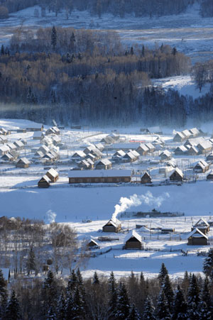 Photo taken on Jan. 4, 2009 shows the scenery of Hemu village of Burqin County in northwestern China's Xinjiang Uygur Autonomous Region. In winter, heavy snow covers trees and hills at the scenic spot of Burqin County.[Sadat/Xinhua]