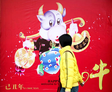 A citizen walks by a large poster of the OX Year on a street of Nanjing, capital of east China's Jiangsu Province, Jan. 2, 2009. Different kinds of festive posters appeared along streets of Nanjing as Spring Festival approaches, making the historic city quite beautiful. [Wang Xin/Xinhua] 