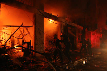 Palestinian firemen operate on a fire at a building used by Hamas members which was hit during an Israeli strike in Gaza City, Jan. 3, 2009. The Israel Defense Forces Saturday evening began its ground incursion into the Hamas-controlled Gaza Strip, vowing to destroy "terror infrastructure" of Hamas. And more than 450 Palestinians has been killed and some 2,300 wounded during Israeli ongoing intensive airstrikes since Dec. 27, 2008. 