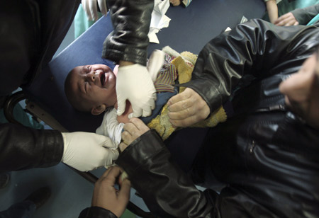 A Palestinian baby wounded by an Israeli tank shell is treated by doctors at Shifa hospital in Gaza Jan. 5, 2009. [Xinhua] 