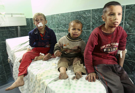 Palestinian boys wounded by an Israeli tank shell wait for treatment at Shifa hospital in Gaza Jan. 5, 2009. [Xinhua]