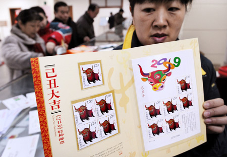 A postal official shows stamps marking the Chinese traditional lunar Jichou Year of 2009 at a post office in Qingdao, east China's Shandong Province on Jan. 5, 2009. The stamps, with the image of ox marking the Jichou Year of 2009, was issued by the State Post Bureau nationwide on Monday. [Xinhua] 
