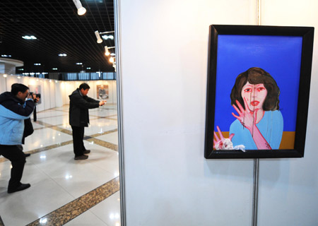 Visitors take photos of paintings during the first art exhibition of China, South Korea, Japan and Russia, in Harbin, capital of northeast China's Heilongjiang Province, Jan. 5, 2009. [Xinhua]