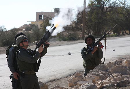 Israeli soldiers fire tear gas at Palestinian protestors during a clash in the West Bank city of Hebron, on Jan. 5, 2009. Palestinians on Monday held a protest in Hebron against Israeli attacks on the Gaza Strip and clashed with Israeli soldiers.[Xinhua]