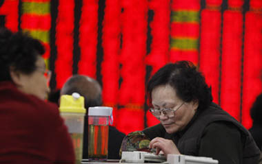 Traders focus on the share prices at a securities exchange in Shanghai, China, on Jan. 5, 2009. The benchmark Shanghai Composite Index on Monday advanced 3.29 percent to 1,880.72. The Shenzhen index also climbed 2.30 percent to 6,634.88 in the first operational day of year 2009. [Xinhua]