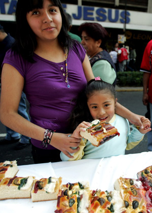 Local residents taste a piece of bread in Mexico City, Mexico, on Jan. 4, 2009. [Xinhua]