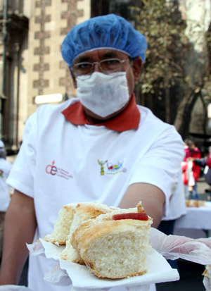 A worker displays a piece of bread in Mexico City, Mexico, on Jan. 4, 2009. [Xinhua]