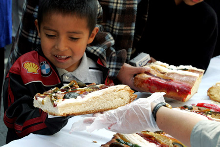  A boy gets a piece of bread in Mexico City, Mexico, on Jan. 4, 2009. [Xinhua]