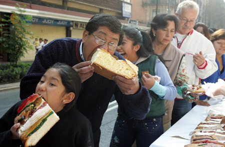 Local residents taste a piece of bread in Mexico City, Mexico, on Jan. 4, 2009. [Xinhua]