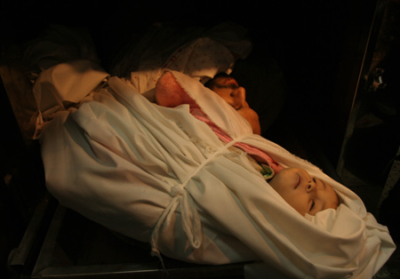 The body of a Palestinian child lay on a stretcher at Shifa hospital in the east of Gaza City after an Israeli strike on Jan. 5, 2009. [Xinhua]