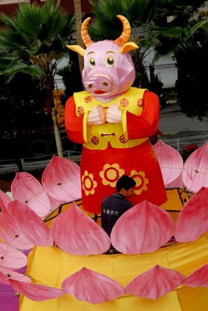 A worker displays an ox-shaped lantern inside a temple in Kuala Lumpur, Malaysia, Jan. 2, 2009. The lantern is displayed here as a kind of decoration to greet the Chinese lunar New Year, or the Year of Ox, which will start from Jan. 26 this year. (Xinhua/Chong Voon Chung)