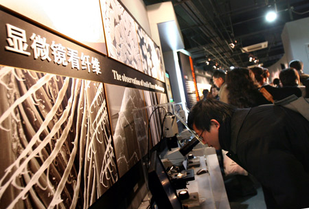 A visitor looks at the fibres of textile through a microscope in newly opened Shanghai Textile and Raiment Museum in Shanghai, China, on Jan. 5, 2009. (Xinhua Photo) 