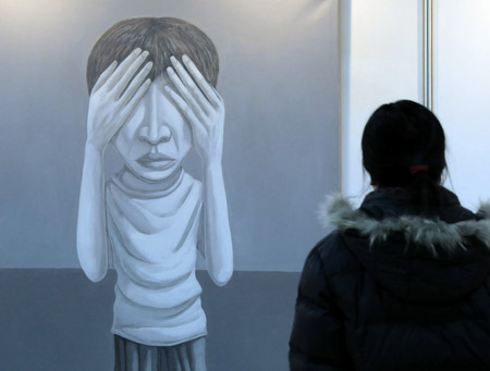 A woman views a painting during the first art exhibition of China, South Korea, Japan and Russia, in Harbin, capital of northeast China's Heilongjiang Province, Jan. 5, 2009. Fourteen artists from the four countries presented their creations during the 10-day art show, opened on Monday.