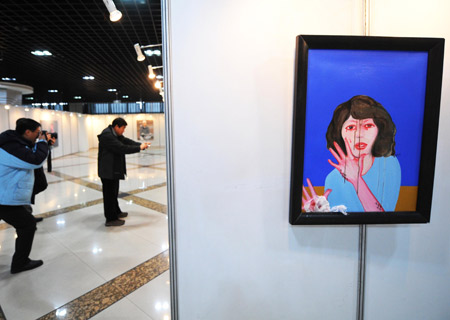 Visitors take photos of paintings during the first art exhibition of China, South Korea, Japan and Russia, in Harbin, capital of northeast China's Heilongjiang Province, Jan. 5, 2009. 