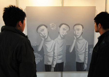 People view a painting during the first art exhibition of China, South Korea, Japan and Russia, in Harbin, capital of northeast China's Heilongjiang Province, Jan. 5, 2009. 