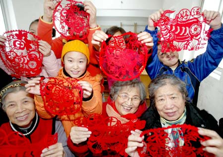 Residents show paper-cuts made by themselves to mark the coming Year of Ox in Chinese lunar calendar, at Siping Street Community in Shenyang, capital of northeast China's Liaoning Province, Dec. 27, 2008. 