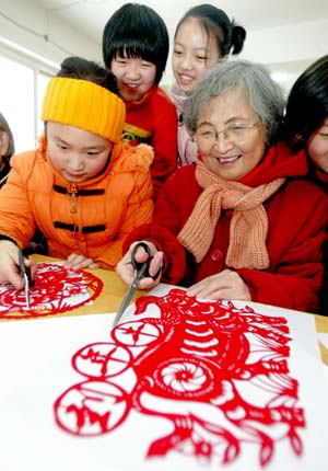 Residents make paper-cuts to mark the coming Year of Ox in Chinese lunar calendar, at Siping Street Community in Shenyang, capital of northeast China's Liaoning Province, Dec. 27, 2008. 