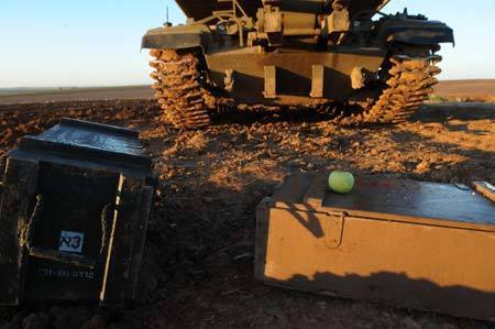 Cartridge caissons are seen in front of an Israeli armored personnel vehicle in the early morning on the border of the northern Gaza Strip, Jan. 6, 2009. Over 540 Palestinians have been killed and some 2,500 others injured in the Gaza Strip during Israel's Operation Cast Lead starting from Dec. 27, 2008. [Yin Bogu/Xinhua]