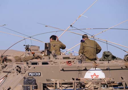 Israeli soldiers await orders on an armored personnel vehicle in the early morning on the border of the northern Gaza Strip, Jan. 6, 2009. Over 540 Palestinians have been killed and some 2,500 others injured in the Gaza Strip during Israel's Operation Cast Lead starting from Dec. 27, 2008. [Yin Bogu/Xinhua]