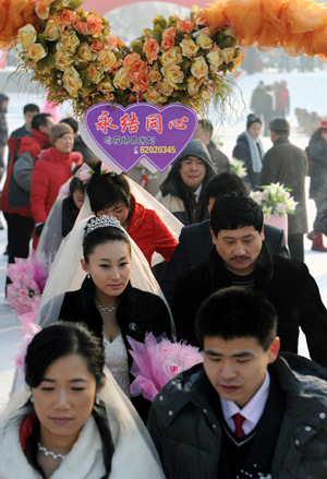 Brides and bridegrooms walk into a mass wedding ceremony held on Sun Island of in Harbin, capital of China's northeast Heilongjiang Province, on Jan. 6, 2009. The 25th Harbin Mass Wedding Ceremony was held on Tuesday with 22 couple attended.[Li Yong/Xinhua] 