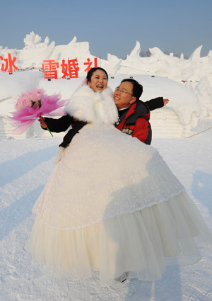 A couple pose for photos at a mass wedding ceremony held on Sun Island of in Harbin, capital of China's northeast Heilongjiang Province, on Jan. 6, 2009. The 25th Harbin Mass Wedding Ceremony was held on Tuesday with 22 couple joined in.[Wang Jianwei/Xinhua]