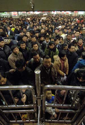 Passengers wait to board on the train at the Xi'an Railway Station in Xi'an, the capital city of Shaanxi Province, Jan. 6, 2009. The Spring Festival starts from Jan. 26 this year, according to Chinese traditional lunar calendar.[Xinhua]