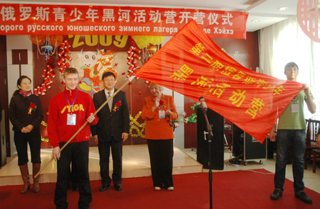 Representatives of a Russian youth camp shows their flag during the opening ceremony held in Heihe, northeast China's Heilongjiang Province, Jan. 5, 2009. The members of camp will take part in cultural exchange activities, such as Russian-Chinese language contest, drawings, Chinese traditional opera leaning etc.[Qiu Qilong/Xinhua]